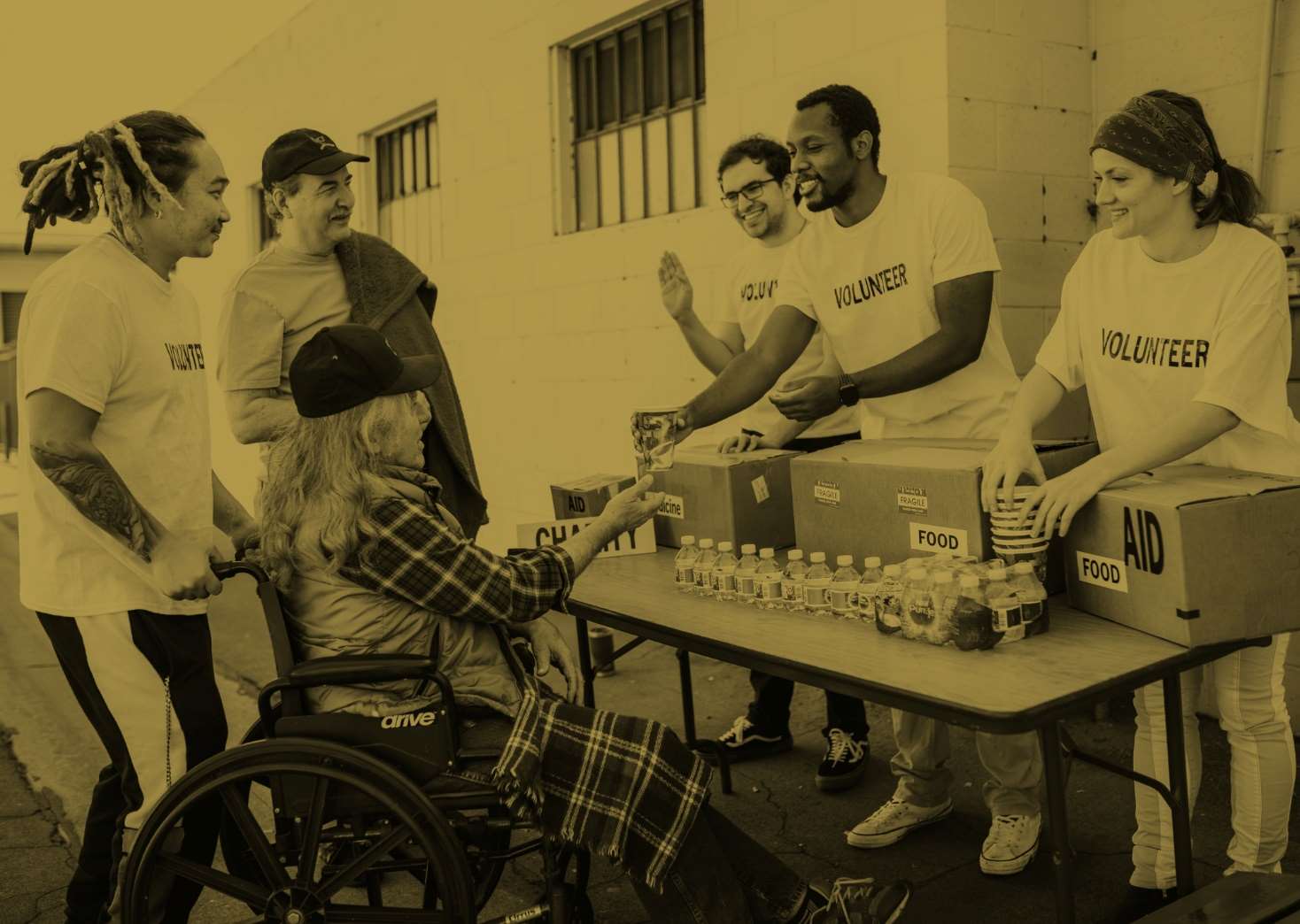 Group of volunteers serving a man in a wheelchair