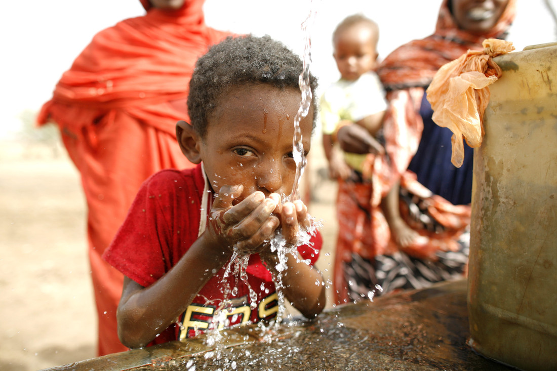Child in Sudan drinking clean water