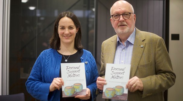Claire Niclasen and Myles Wilson holding copies of their book Personal Support Matters